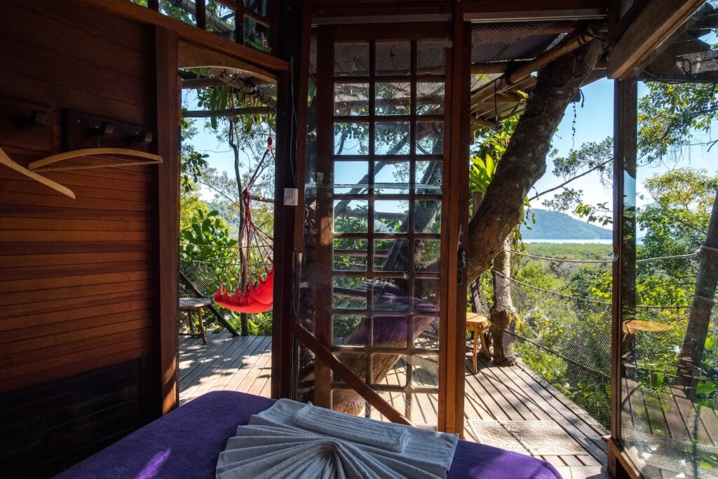 Vista interna da casa na árvore em Paraty, com varanda para a natureza.